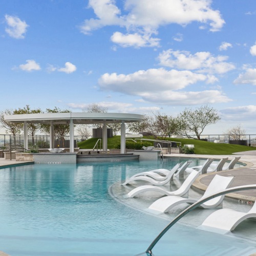 resort-style pool with chairs and deck  at Drewery Place - Apartments in Houston, Texas